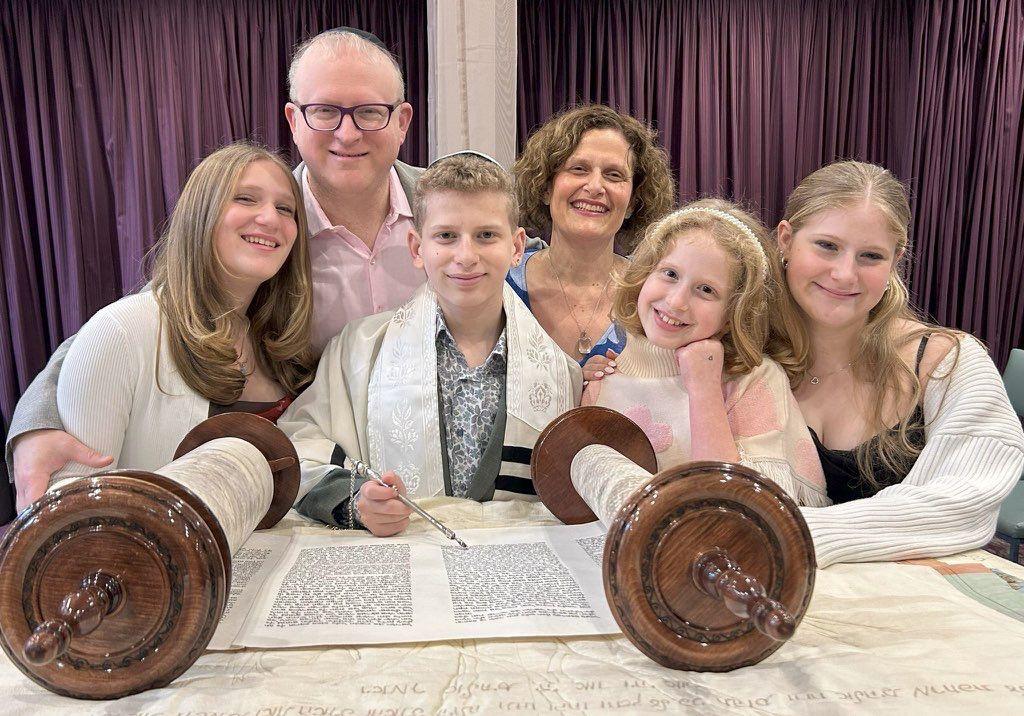 Family gathered around the Torah at a Shira bar mitzvah